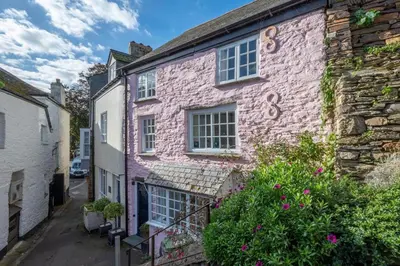 an old brick house with flowers in front of it at 3 Bed in Fowey oc-litin in Fowey