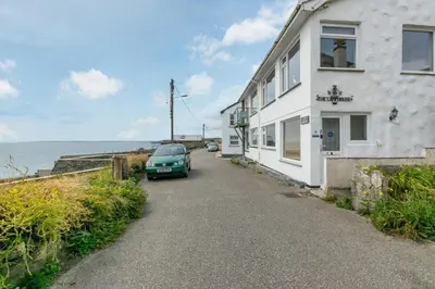 a car parked on the side of a house next to the ocean at 2 Bed in Porthleven oc-lampho in Porthleven