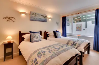 two beds in a room with blue curtains at 2 Bed in Porthleven oc-lampho in Porthleven