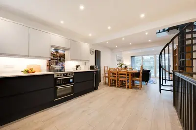 a kitchen with white cabinets and a dining room at 3 Bed in Looe oc-l30071 in Looe
