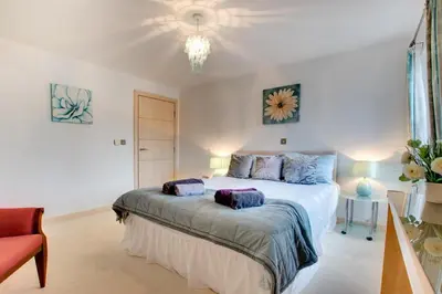 a bedroom with a bed with purple pillows on it at 2 Bed in Looe oc-l30065 in Looe