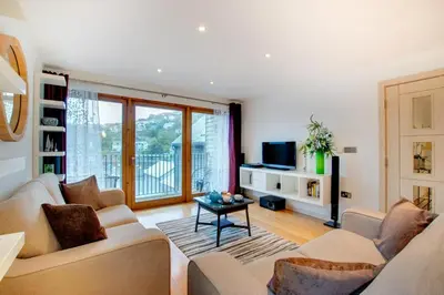 a living room with two couches and a table at 2 Bed in Looe oc-l30065 in Looe