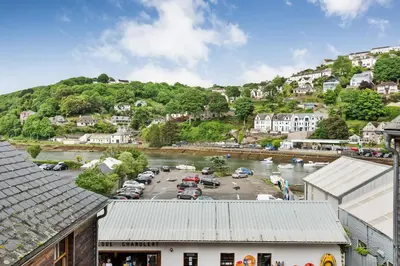 a town with cars parked in a parking lot next to a river at 2 Bed in Looe oc-l30065 in Looe