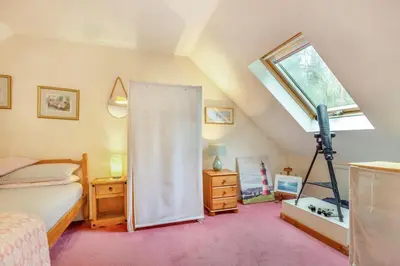 a attic bedroom with a bed and a window at 3 Bed in Looe oc-l30064 in Looe