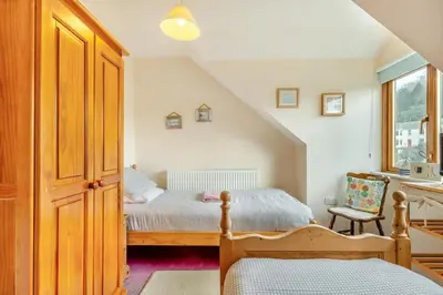 a bedroom with a bed and a chair at 3 Bed in Looe oc-l30064 in Looe