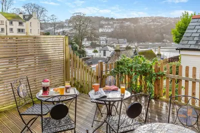 a patio with two tables and chairs on a balcony at 3 Bed in Looe oc-l30064 in Looe