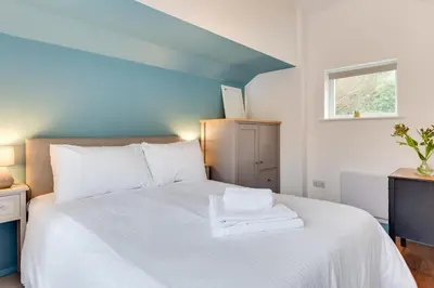 a bedroom with a bed with white sheets and a window at 1 Bed in Duloe oc-l30057 in Duloe