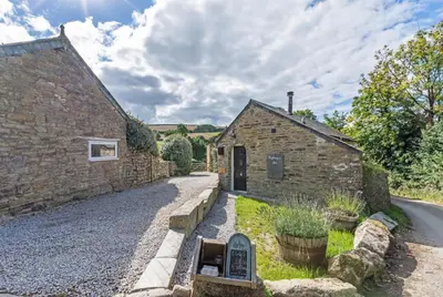 a stone building with a sign next to a street at 1 Bed in Duloe oc-l30057 in Duloe