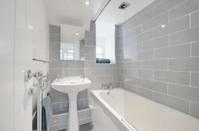 a white bathroom with a sink and a bath tub at 2 Bed in West Looe oc-l30054 in Looe