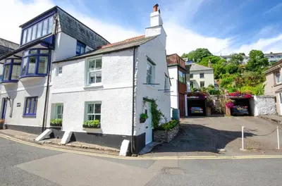 a white house with a tower on a street at 2 Bed in West Looe oc-l30054 in Looe