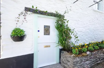 a white house with a white door and some plants at 2 Bed in West Looe oc-l30054 in Looe