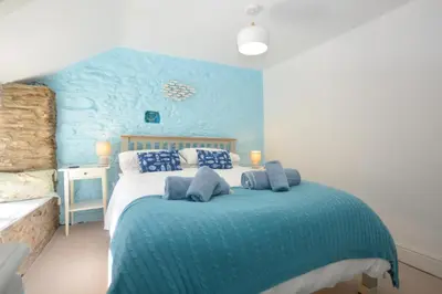 a bedroom with a bed with a blue wall at 3 Bed in Looe oc-l30053 in Looe