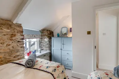 a bedroom with a bed and a dresser in a room at 3 Bed in Looe oc-l30053 in Looe