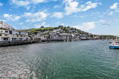 a river with buildings and a boat in the water at 3 Bed in Looe oc-l30053 in Looe