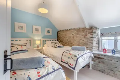 a attic bedroom with two beds and a window at 3 Bed in Looe oc-l30053 in Looe