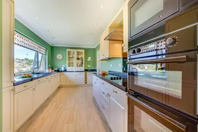 a large kitchen with white cabinets and green walls at 3 Bed in Mevagissey oc-windru in Mevagissey