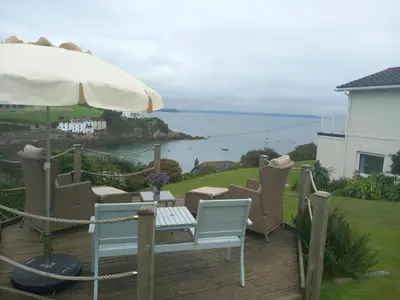 a patio with a table and chairs and an umbrella at 3 Bed in Mevagissey oc-windru in Mevagissey
