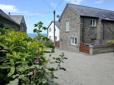 a stone house with a garden in front of it at The Mill in Tintagel