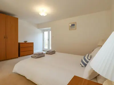 a bedroom with a large white bed and a window at The Mill in Tintagel
