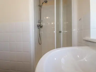 a bathroom with a shower and a white tub at The Mill in Tintagel