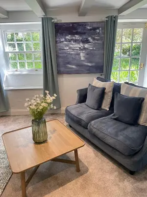 a living room with a couch and a table at 2 Penmayne Cottage in Saint Minver