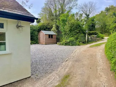 a gravel road next to a small shed at 2 Penmayne Cottage in Saint Minver