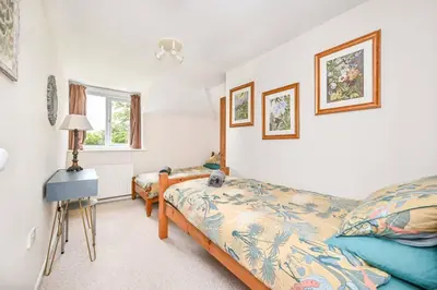 a bedroom with two beds and a lamp at Wykeham Coach House in Looe