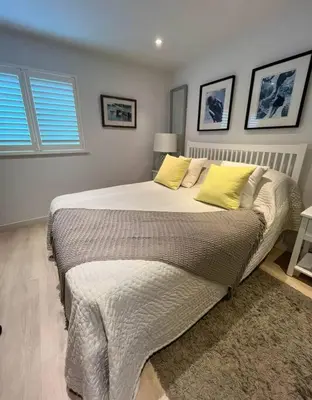 a bedroom with a large bed with yellow pillows at Number 9, Port Isaac Bay Holidays in Port Isaac