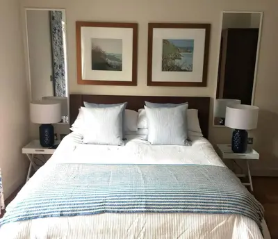 a bedroom with a large bed with two lamps on tables at Number 9, Port Isaac Bay Holidays in Port Isaac