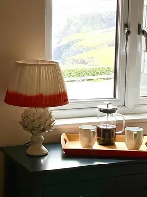 a table with a lamp and two coffee cups on it at Number 9, Port Isaac Bay Holidays in Port Isaac