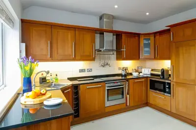 a kitchen with wooden cabinets and a counter top at Number 9, Port Isaac Bay Holidays in Port Isaac