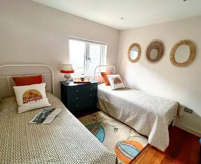 two beds in a bedroom with mirrors on the wall at Number 9, Port Isaac Bay Holidays in Port Isaac