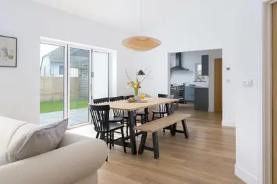 a dining room and living room with a table and chairs at The Hideaway, Modern 3 bed in Tintagel, Cornwall in Tintagel