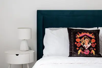 a bed with a pillow with a picture of a woman at The Hideaway, Modern 3 bed in Tintagel, Cornwall in Tintagel
