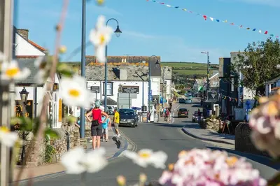 a couple of people walking down a city street at The Hideaway, Modern 3 bed in Tintagel, Cornwall in Tintagel