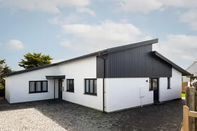 a white and black house with a black roof at The Hideaway, Modern 3 bed in Tintagel, Cornwall in Tintagel