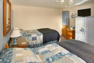 a hotel room with two beds and a television at Vine Cottage in Penpillick