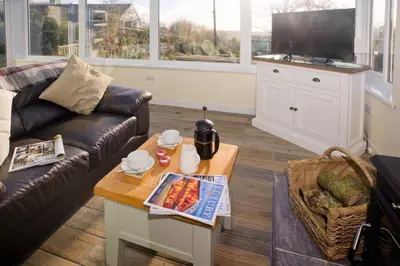 a living room with a couch and a coffee table at Vine Cottage in Penpillick