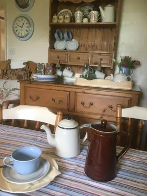 a table with a teapot and a tea pot at Vine Cottage in Penpillick