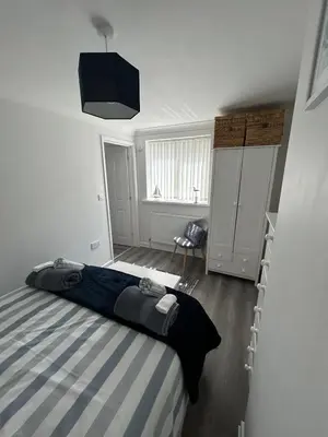 a bedroom with a bed with a blue and white stripes at Ruby's Den in Carbis Bay