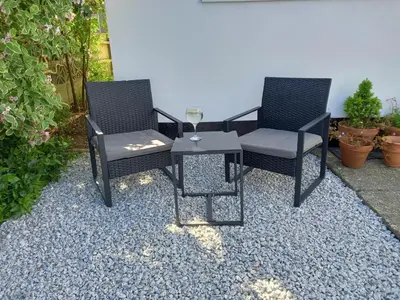 two chairs and a table on a gravel patio at Ruby's Den in Carbis Bay