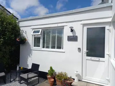 a white house with a window and a door at Ruby's Den in Carbis Bay