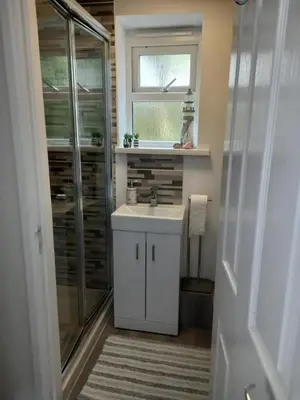 a bathroom with a white sink and a shower at Ruby's Den in Carbis Bay