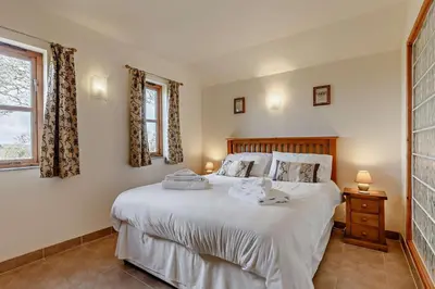 a bedroom with a large white bed and a window at 1 Bed in Garras oc-l27431 in Mawgan