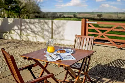 a wooden table with a plate of food and orange juice at 1 Bed in Garras oc-l27431 in Mawgan