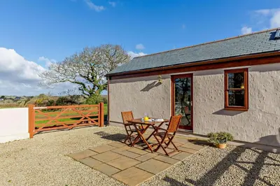 a patio with a table and chairs next to a building at 1 Bed in Garras oc-l27431 in Mawgan