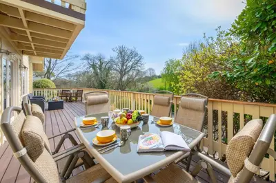 a table with a bowl of fruit on a deck at 3 Bed in Little Petherick oc-maplod in Little Petherick