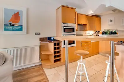 a kitchen with wooden cabinets and a island with a bar at 2 Bed in Porthleven oc-marin2 in Porthleven