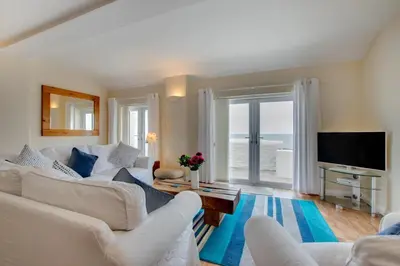 a living room with white furniture and a large window at 2 Bed in Porthleven oc-marin2 in Porthleven