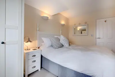 a bedroom with a white bed and a white dresser at 2 Bed in Porthleven oc-marin2 in Porthleven